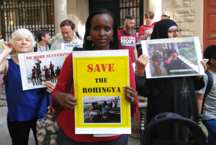 Jacqueline Murekatete holds sign saying "Save the Rohingya"